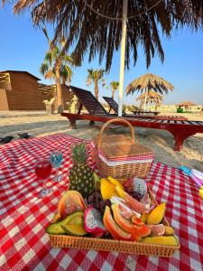una mesa de picnic con una cesta de fruta y una copa de vino en Cielo Beach Resort 