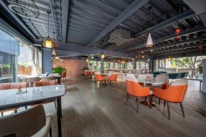 a restaurant with orange chairs and tables in a room at Guangzhou Yunzhu Hotel in Guangzhou