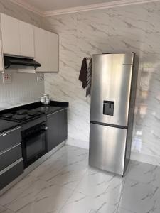 a stainless steel refrigerator in a kitchen with marble walls at White Rhino apartments & tours in Livingstone