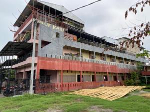 un bâtiment en construction avec des personnes sur le balcon dans l'établissement OYO 93414 Wisma Ratu Syariah, à Parepare