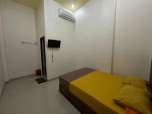 ParepareにあるOYO 93414 Wisma Ratu Syariahのベッドルーム1室(ベッド1台、壁にエアコン付)