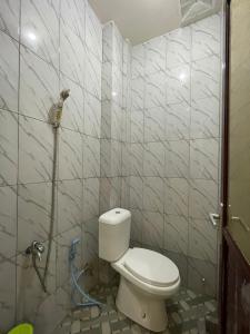 a bathroom with a toilet and a shower at OYO 93414 Wisma Ratu Syariah in Parepare