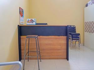 een bar met 2 krukken en een aanrecht in een kamer bij Hotel O Pondok Kula Rumbih Syariah in Sungairasau