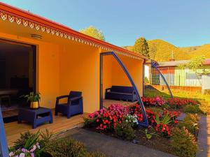 ein orangefarbenes Haus mit einer Terrasse mit Blumen in der Unterkunft AU JASMIN DE NUIT in La Plaine des Palmistes
