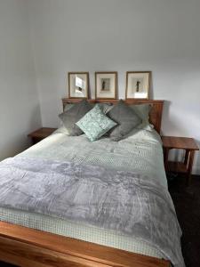 um quarto com uma cama com três fotografias na parede em Ingram Farm Colebrook 