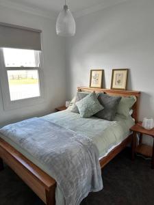 um quarto com uma cama com almofadas e uma janela em Ingram Farm Colebrook 