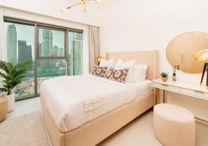 a bedroom with a large bed and a window at BURJ ROYALE - Luxury 2 bedroom apartment with full burj Khalifa & fountain view- DELUXE in Dubai
