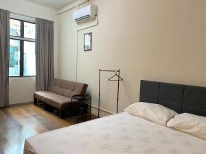 a bedroom with a bed and a chair and a window at Aayu Chulia in George Town