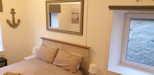 1 dormitorio con cama y espejo en la pared en Penbryn Holidays, Barmouth en Barmouth