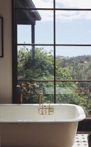 a bath tub in a bathroom with a window at Blue Hills Luxury Farm Stay in Tilba Tilba