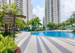 a swimming pool in a city with tall buildings at Tranquil Sea View Danga Bay 3BR 6pax by Our Stay in Johor Bahru