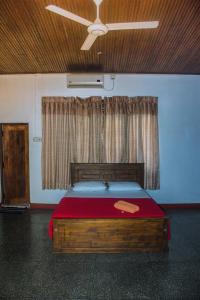 a bedroom with a large wooden bed with a window at Spice & Herb Rooms & Food in Kandy