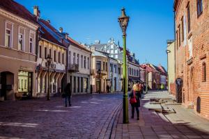 a street with people walking down a cobblestone street at Picturesque Old Town Apartment with Charming Balcony in Kaunas