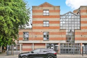 um carro estacionado em frente a um edifício de tijolos em Modern 1 Bed Apartment Camden em Londres