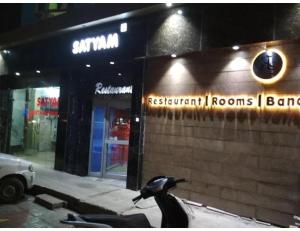 a penguin is standing outside of a restaurant rooms bar at Hotel Satyam, Kanpur in Kānpur