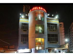 a building with a neon sign on top of it at Hotel Satyam, Kanpur in Kānpur
