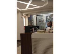 a man sitting at a counter in a restaurant at Hotel Satyam, Kanpur in Kānpur