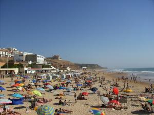 una multitud de personas en una playa con sombrillas en Pátio Mateus, en Areia Branca