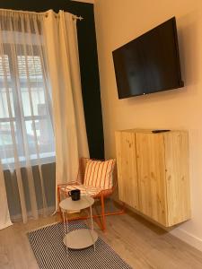 a living room with a chair and a flat screen tv at Goldsmith in Sibiu