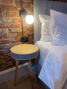 a bed and a table with a lamp next to a bed at Goldsmith in Sibiu