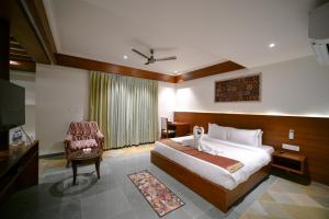 um quarto de hotel com uma cama e uma cadeira em The Ramvilas - A Rooftop Pichola Lake View Hotel em Udaipur