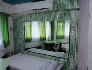 a mirror in a room with a bed and a table at QUICKSHIELD HOMESTAY in Naga
