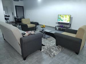 Gandigal的住宿－beautiful home in Malikounda .，客厅配有两张沙发和一台电视机
