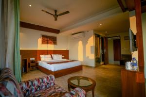 um quarto de hotel com uma cama e um sofá em The Ramvilas - A Rooftop Pichola Lake View Hotel em Udaipur