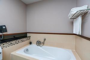 a bath tub in a bathroom with a telephone at Tara Mantra Cha-Am Resort in Cha Am