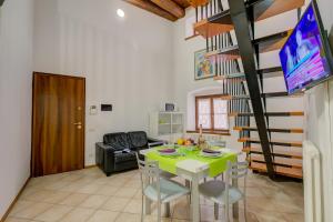 a living room with a dining table and a spiral staircase at Casa Alpino - Happy Rentals in Riva del Garda