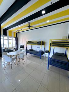 Cette chambre comprend 2 lits superposés, une table et des chaises. dans l'établissement Austin Manhattan Design Avant Suite by Double A, à Johor Bahru