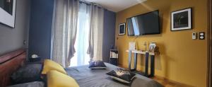 um quarto com uma cama e uma televisão na parede em Chambre d'hôtes Casa Lucia em Furiani