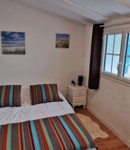 um quarto com uma cama e uma janela em La Maison du pêcheur - Jacuzzi em Jard-sur-Mer