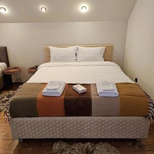 a bedroom with a bed with two towels on it at Misha's House in Porumbacu de Sus