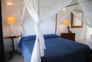 a bedroom with a blue bed with a canopy at camera matrimoniale grande terrazza vista stupenda in Nosy Be