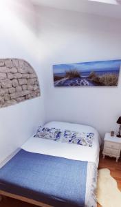 um quarto com uma cama com duas fotografias na parede em La Maison du pêcheur - Jacuzzi em Jard-sur-Mer