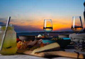 沙特拉永普拉日的住宿－Hôtel Le Rivage vue sur mer - Châtelaillon-plage，一张桌子,上面有食物和两杯葡萄酒