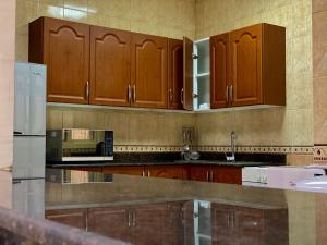cocina con armarios de madera y microondas en Al Misrea Tower, en Juffair
