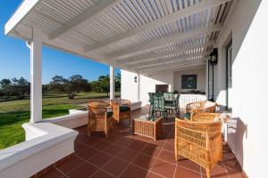 a patio with awning and chairs and a table at Greenhill Farm Parklands Cottage - 2 bedroom 4 guests - Private House in Plettenberg Bay