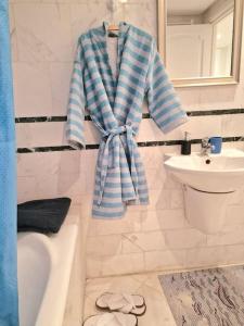 uma casa de banho com uma toalha azul e branca pendurada numa parede em The bleu sea em Tunes