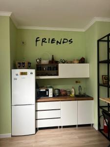 a kitchen with a white refrigerator and a counter top at Friends Hostel in Astana