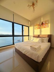 - une chambre avec un lit et une vue sur l'océan dans l'établissement Sunset Seaview Studio Apartment at Kota Kinabalu City Centre, à Kota Kinabalu