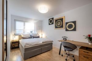 a bedroom with a bed and a desk and a chair at Alpenflair / Luxury / 100qm / Work / Travel / Netflix in Penzberg