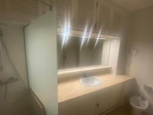 La salle de bains est pourvue d'un lavabo et d'un miroir. dans l'établissement Macrina, à Tamariu