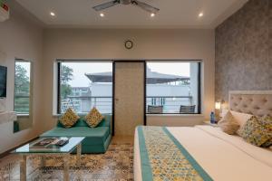 a bedroom with a bed and a couch and windows at La Sunila Suites & Villas by WSI, Baga in Baga