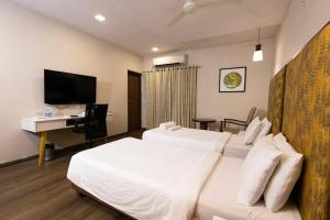 ヴィシャカパトナムにあるClassic Boutique Hotel & Luxury Service Apartmentsのベッド2台とデスクが備わるホテルルームです。