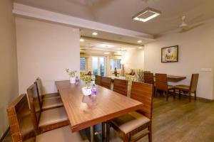 - une salle à manger avec une table et des chaises en bois dans l'établissement Classic Boutique Hotel & Luxury Service Apartments, à Visakhapatnam