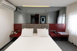 een slaapkamer met een groot bed met witte kussens bij Voir Hotel Pera in Istanbul