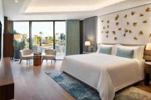 Reges, a Luxury Collection Resort & Spa, Cesme في تشيشمي: غرفة نوم مع سرير أبيض كبير مع طيور على الحائط