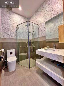 a bathroom with a shower and a toilet and a sink at HANZ Teddy Sunset Grand World in Phú Quốc